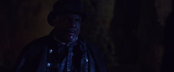 Movie still from “Black as Night” (2021), directed by Maritte Lee Go – A man wearing a hat and a leather jacket; Close Up shot, Over the shoulder angle