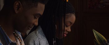 Movie still from “Black as Night” (2021), directed by Maritte Lee Go – A man and a woman with long braids; Close Up shot, Over the shoulder angle