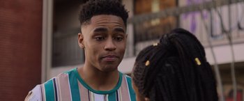 Movie still from “Black as Night” (2021), directed by Maritte Lee Go – A man with a beard and a striped t - shirt is talking to a woman; Close Up shot, Over the shoulder angle