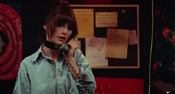 Movie still from “Black Christmas” (1974), directed by Bob Clark – A woman talking on a phone in front of a bulletin board; Close Up shot, High angle