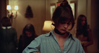 Movie still from “Black Christmas” (1974), directed by Bob Clark – A woman wearing a blue button up shirt and a black choker; Close Up shot, Over the shoulder angle