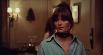 Movie still from “Black Christmas” (1974), directed by Bob Clark – A woman wearing a black choker and a blue shirt; Close Up shot, Over the shoulder angle