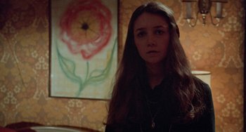 Movie still from “Black Christmas” (1974), directed by Bob Clark – A woman standing in front of a painting in a room; Close Up shot, High angle