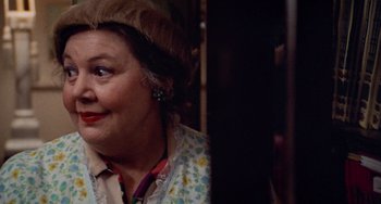 Movie still from “Black Christmas” (1974), directed by Bob Clark – An older woman wearing a floral shirt and a fur hat; Close Up shot, Over the shoulder angle