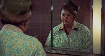Movie still from “Black Christmas” (1974), directed by Bob Clark – An older woman looking in the mirror in front of a mirror; Close Up shot, Over the shoulder angle