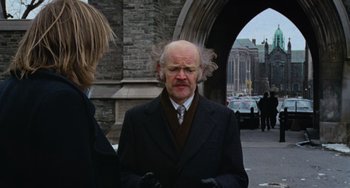 Movie still from “Black Christmas” (1974), directed by Bob Clark – An older man with a long white beard; Medium shot, Over the shoulder angle