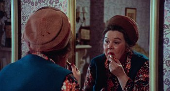 Movie still from “Black Christmas” (1974), directed by Bob Clark – An older woman putting lipstick on in front of a mirror; Close Up shot, Over the shoulder angle