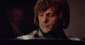 Movie still from “Black Christmas” (1974), directed by Bob Clark – A person sitting at a piano; Close Up shot, Low angle