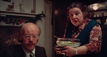 Movie still from “Black Christmas” (1974), directed by Bob Clark – An older man and a younger woman in a room; Close Up shot, Over the shoulder angle