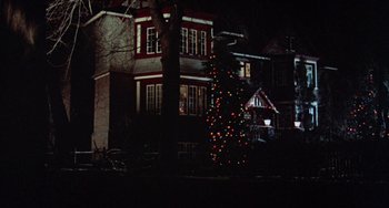 Movie still from “Black Christmas” (1974), directed by Bob Clark – A lit up christmas tree in front of a house; Extreme Wide shot, Low angle