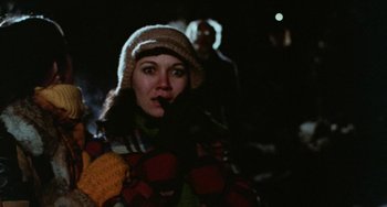 Movie still from “Black Christmas” (1974), directed by Bob Clark – A woman in a hat smoking a cigarette in the dark; Close Up shot, Over the shoulder angle