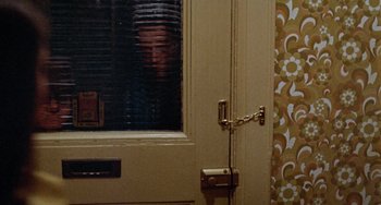 Movie still from “Black Christmas” (1974), directed by Bob Clark – A door and a window; Wide shot, Over the shoulder angle