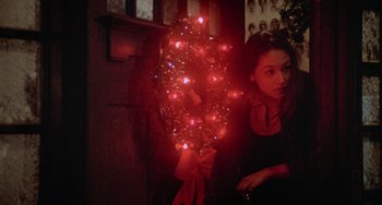 Movie still from “Black Christmas” (1974), directed by Bob Clark – A woman sitting in front of a christmas tree; Close Up shot, Over the shoulder angle