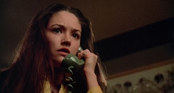 Movie still from “Black Christmas” (1974), directed by Bob Clark – A woman is talking on a phone while wearing a yellow shirt; Close Up shot, Low angle