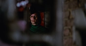 Movie still from “Black Christmas” (1974), directed by Bob Clark – A man wearing a green sweater looking into a mirror; Medium shot, Low angle