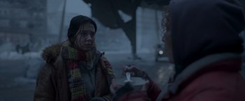 Movie still from “Black Crab” (2022), directed by Adam Berg – A woman in a scarf is talking to another woman; Medium shot, Over the shoulder angle
