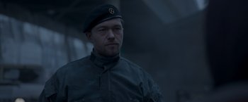 Movie still from “Black Crab” (2022), directed by Adam Berg – A man in a military uniform wearing a hat; Close Up shot, Low angle