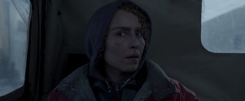 Movie still from “Black Crab” (2022), directed by Adam Berg – A person with a hooded jacket looking at the camera; Close Up shot, Over the shoulder angle