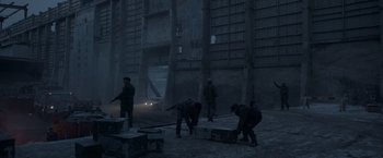 Movie still from “Black Crab” (2022), directed by Adam Berg – A group of men standing next to each other on a street; Wide shot, Low angle