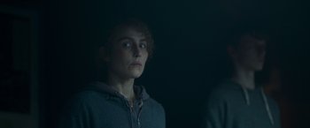 Movie still from “Black Crab” (2022), directed by Adam Berg – A woman in a hooded jacket looking at the camera; Close Up shot, Low angle