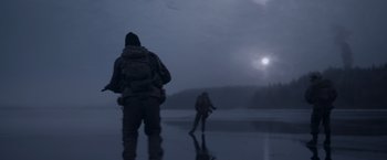 Movie still from “Black Crab” (2022), directed by Adam Berg – Two people standing on the shore of a body of water at night; Wide shot, Low angle