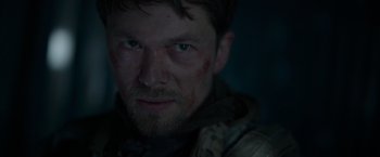 Movie still from “Black Crab” (2022), directed by Adam Berg – A person with a face covered in blood; Close Up shot, Low angle