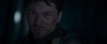 Movie still from “Black Crab” (2022), directed by Adam Berg – A person with a bruise on his face; Close Up shot, Low angle