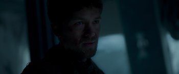 Movie still from “Black Crab” (2022), directed by Adam Berg – A person with a beard looking at the camera; Close Up shot, Low angle