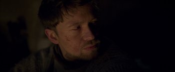 Movie still from “Black Crab” (2022), directed by Adam Berg – A person looking at the camera; Close Up shot, Low angle