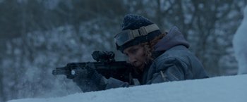Movie still from “Black Crab” (2022), directed by Adam Berg – A person with a rifle in the snow; Medium shot, Over the shoulder angle