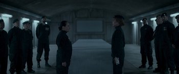 Movie still from “Black Crab” (2022), directed by Adam Berg – Two women in uniform standing next to each other in a room; Medium shot, Over the shoulder angle