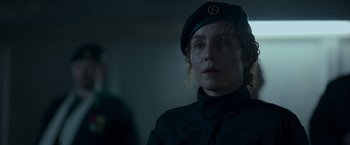 Movie still from “Black Crab” (2022), directed by Adam Berg – A woman in a military uniform is looking at the camera; Close Up shot, Over the shoulder angle