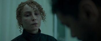 Movie still from “Black Crab” (2022), directed by Adam Berg – A woman with curly red hair sitting in front of a man; Close Up shot, Over the shoulder angle