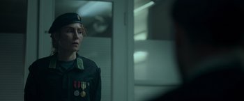 Movie still from “Black Crab” (2022), directed by Adam Berg – A man in a military uniform standing in front of a mirror; Medium shot, Over the shoulder angle