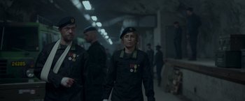Movie still from “Black Crab” (2022), directed by Adam Berg – A group of people in uniform walking in a hallway; Medium shot, Over the shoulder angle