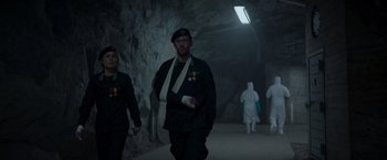 Movie still from “Black Crab” (2022), directed by Adam Berg – A man in a military uniform walking in a cave; Medium shot, Low angle