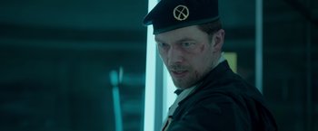 Movie still from “Black Crab” (2022), directed by Adam Berg – A person wearing a hat; Close Up shot, Low angle