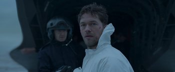 Movie still from “Black Crab” (2022), directed by Adam Berg – A man in a white raincoat and a man in a black jacket; Close Up shot, Over the shoulder angle