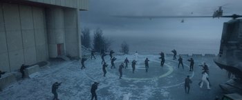 Movie still from “Black Crab” (2022), directed by Adam Berg – A group of people standing on top of a snow covered ground; Extreme Wide shot, High angle