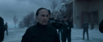 Movie still from “Black Crab” (2022), directed by Adam Berg – A woman in a black jacket and two other men in black jackets; Close Up shot, Over the shoulder angle