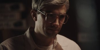 Movie still from “BlackBerry” (2023), directed by Matt Johnson – A person wearing glasses; Close Up shot, High angle