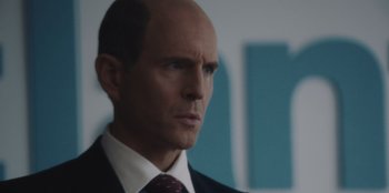 Movie still from “BlackBerry” (2023), directed by Matt Johnson – A man in a suit and tie looking to his left; Close Up shot, Over the shoulder angle