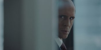 Movie still from “BlackBerry” (2023), directed by Matt Johnson – A man in a suit and tie looking out of a window; Close Up shot, Over the shoulder angle