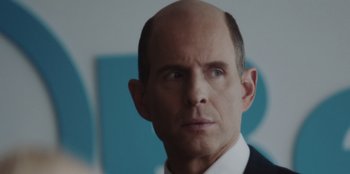 Movie still from “BlackBerry” (2023), directed by Matt Johnson – A man with a bald head is looking at the camera; Close Up shot, Over the shoulder angle