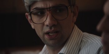 Movie still from “BlackBerry” (2023), directed by Matt Johnson – A person wearing glasses; Close Up shot, Over the shoulder angle