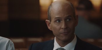 Movie still from “BlackBerry” (2023), directed by Matt Johnson – A man in a suit and tie looking at the camera; Close Up shot, Over the shoulder angle