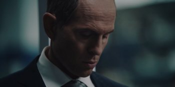 Movie still from “BlackBerry” (2023), directed by Matt Johnson – A person wearing a suit and tie; Close Up shot, Low angle