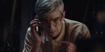 Movie still from “BlackBerry” (2023), directed by Matt Johnson – A man with glasses is talking on a cell phone; Close Up shot, High angle