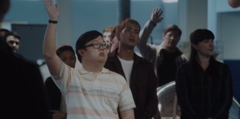 Movie still from “BlackBerry” (2023), directed by Matt Johnson – A group of people standing in front of a wall; Medium shot, Low angle