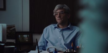 Movie still from “BlackBerry” (2023), directed by Matt Johnson – A man sitting at a table in front of papers; Close Up shot, Over the shoulder angle